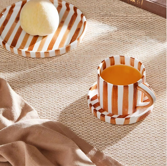Premium ceramic cup and plate set in burnt orange, featuring hand-painted stripes and Nordic-inspired minimalist design for elegant dining.