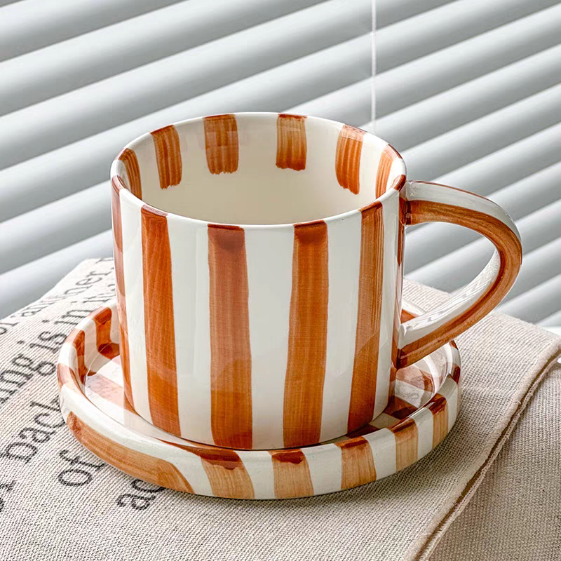 Premium ceramic cup and plate set in burnt orange, featuring hand-painted stripes and Nordic-inspired minimalist design for elegant dining.