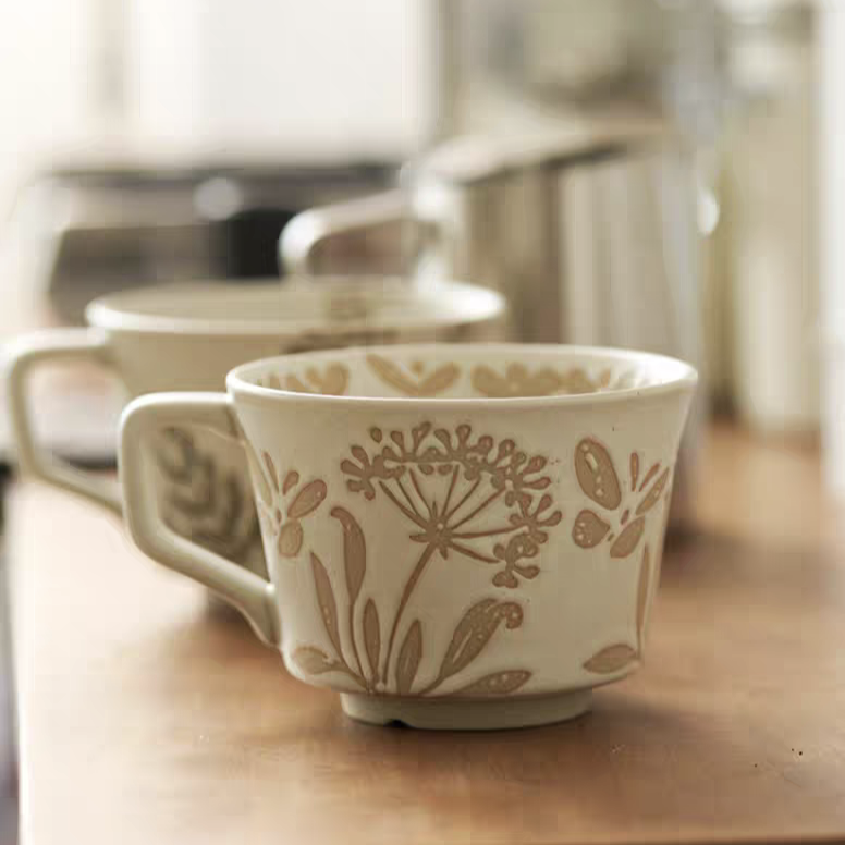 Elegant designed mugs featuring minimalist patterns of leaves and butterflies, perfect for Japandi, cottage, and Nordic styles.