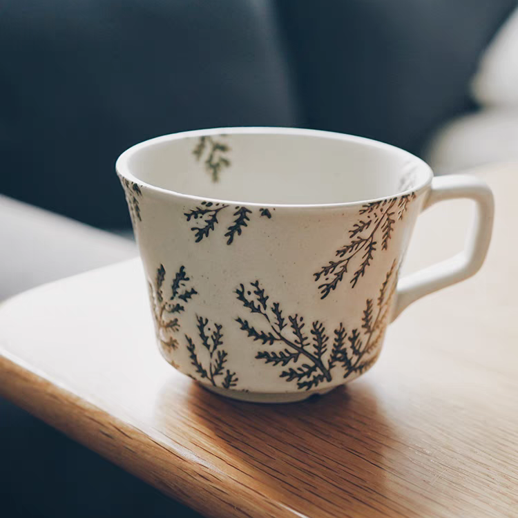 Textured ceramic mug with a graceful willow design, blending retro and Japandi styles in a neutral color.