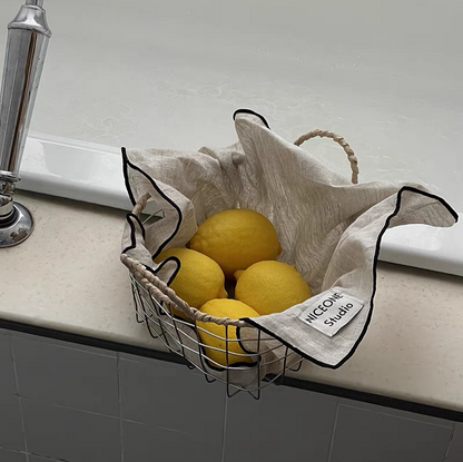 Round woven metal wire basket filled with fruits, showcasing its versatile and decorative features in a warm minimalism setting.