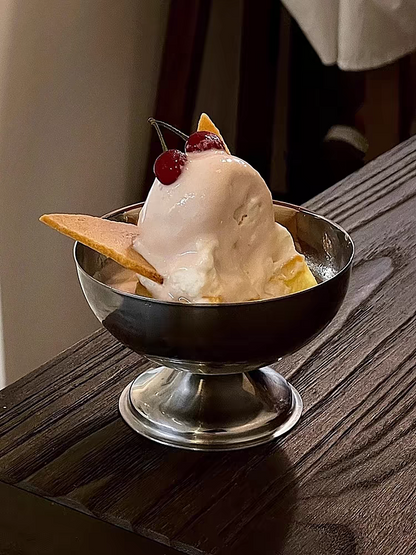 Stainless steel ice cream cup with sleek silver finish, elegantly holding a scoop of vanilla ice cream, showcasing its aesthetic appeal.