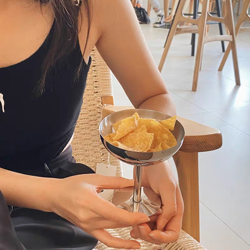 High-footed stainless steel goblet filled with assorted snacks, enhancing modern kitchen aesthetics